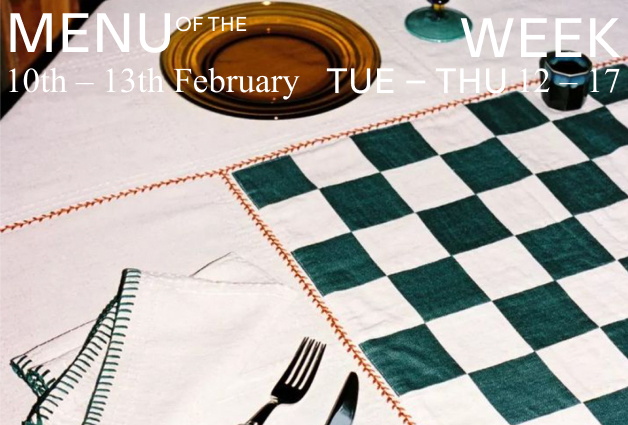 Ausschnitt eines gedeckten Tisches mit karierter Decke und Besteck