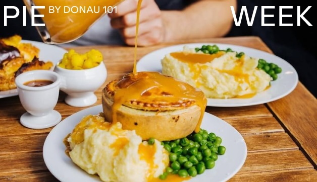 Teller gefüllt mit einem kleinen Küchlein, Kartoffelpüree und Erbsen auf einem Holztisch