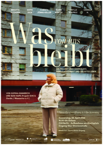 eine ältere Frau in einer beigen Daunenjacke und einer hellbraunen Hose steht entspannt vor einem Hochhaus und schaut in die Ferne